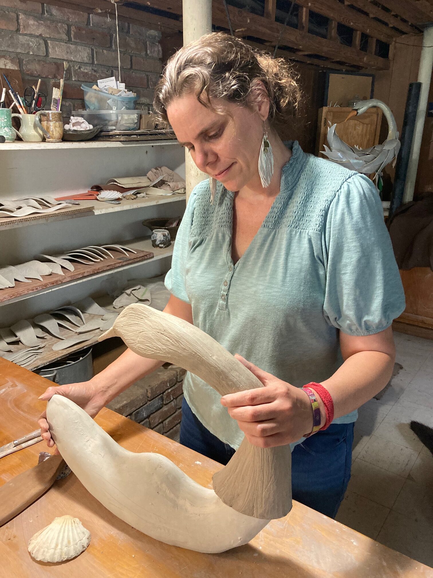 Image of Elizabeth sculpting a ceramic swan sculpture.